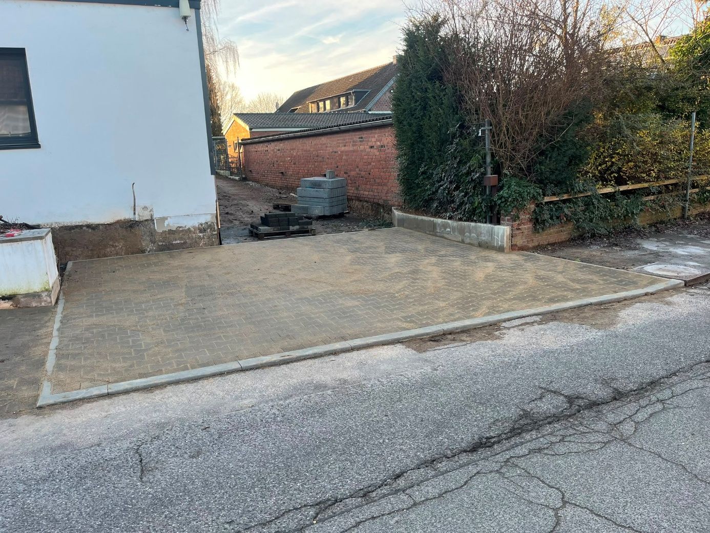 Verdichteter Unterbau einer Hoffläche zwischen zwei Häusern, vorbereitet für die Pflasterdecke